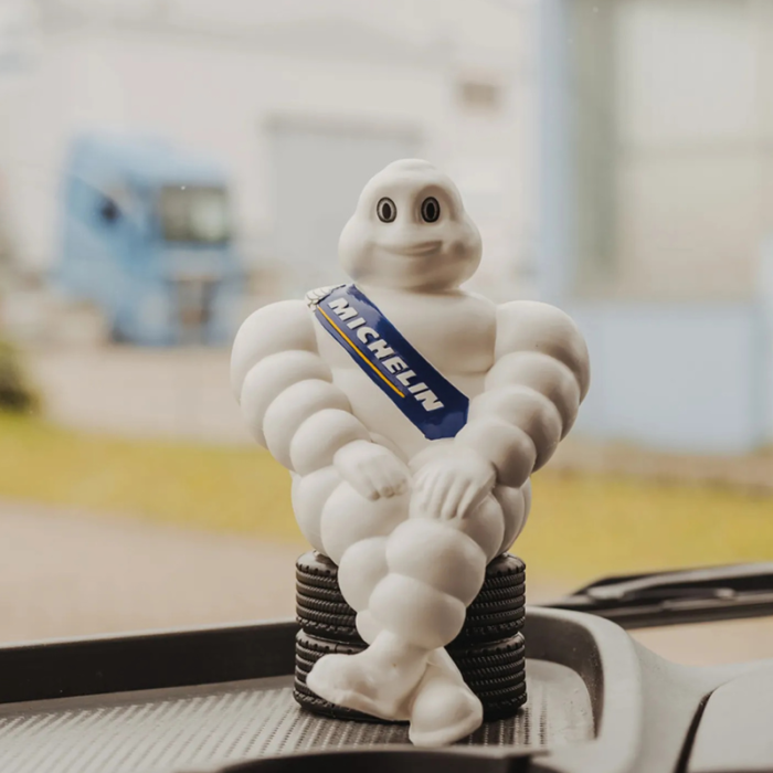 Michelin pop zittend op autobanden geplaatst op een dashboard.